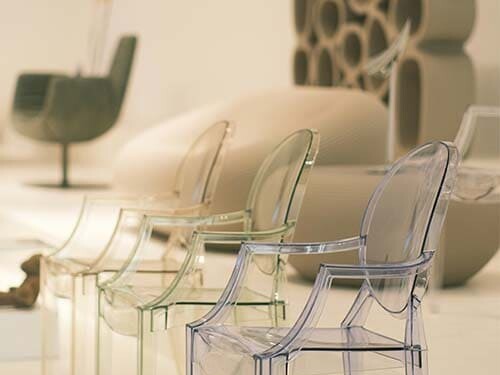 Chaises design aligné dans un showroom avec des fauteuils de créateur en second plan