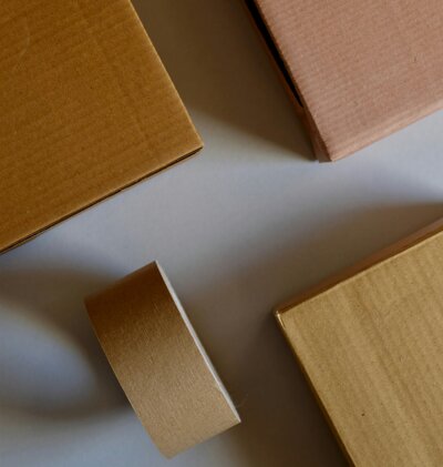 Carton et scotch posé sur une table blanche