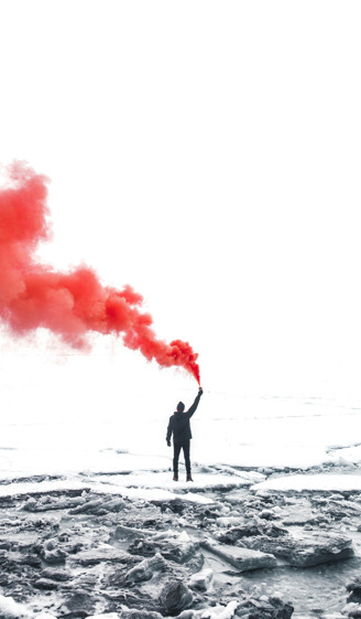 Un homme qui tient un fumigène en l'air dans un cadre glacé