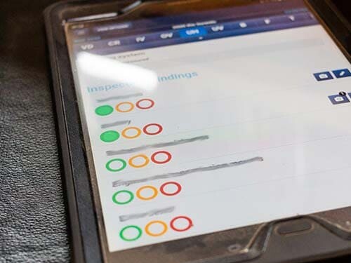 Tablette posée sur un siège de camion avec les statuts de visibles pour chaque client