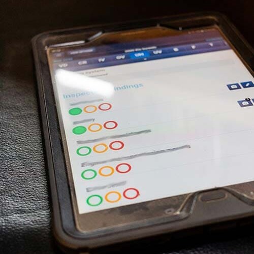 Tablette posée sur un siège de camion avec les statuts de visibles pour chaque client